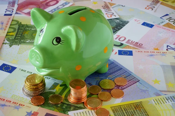 Sparschwein zum Hintergrund des Euro-Geldes — Stockfoto