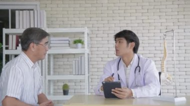 Aile kavramı. Asyalı oğul ve baba oturma odasında tablet oynarken eğleniyorlar. 4k Çözünürlüğü.