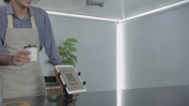 Kahve dükkanı konsepti. Garson müşterilere kahve dağıtıyor ve ödemeleri kabul ediyor. 4k Çözünürlüğü.