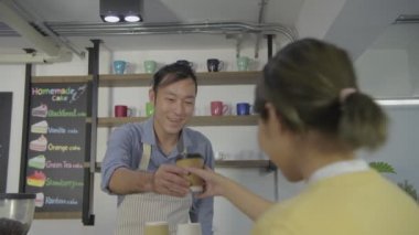 Kahve dükkanı konsepti. Çalışanlar dükkandaki müşterilere kahve servisi yapıyorlar. 4k Çözünürlüğü.