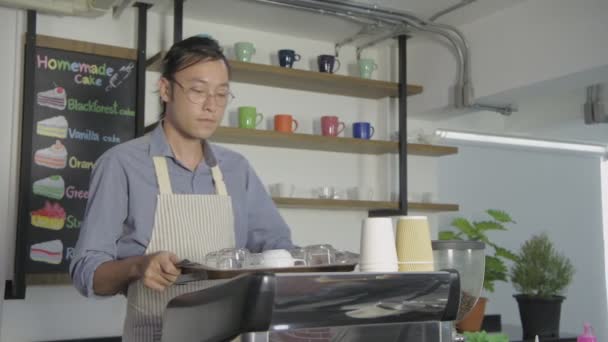 コーヒーショップのコンセプト 従業員は店内で飲料用の容器を準備しています 4K分解能 — ストック動画