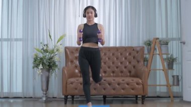 Egzersiz konsepti. Asyalı kızlar evde dambıllarla egzersiz yapıyor. 4k Çözünürlüğü.
