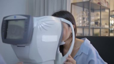 Optik dükkan konsepti. Göz doktoru, müşterinin gözlerini ölçüyor da. 4k Çözünürlüğü.