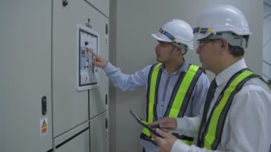 Mühendis konsepti. Yönetici, elektrik ekipmanlarını incelemek için yürüyor. 4k Çözünürlüğü.