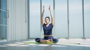 Egzersiz konsepti. Evde yoga yapan genç bir kadın. 4k Çözünürlüğü.