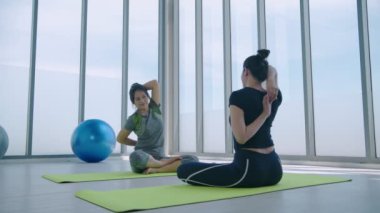 Egzersiz konsepti. Spor salonunda esneme hareketleri yapan bayan sporcular. 4k Çözünürlüğü.
