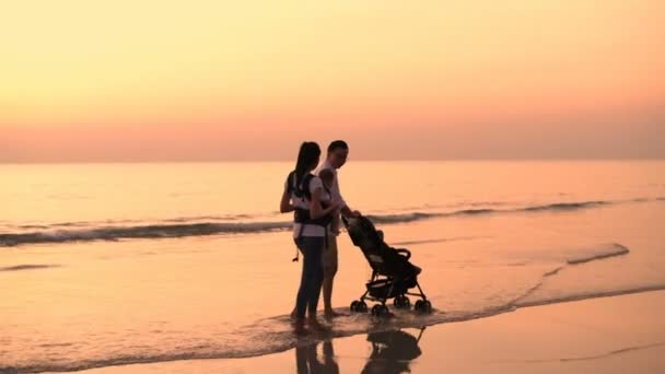 家族の概念 両親は子供たちを連れてビーチを歩いています 4K分解能 — ストック動画