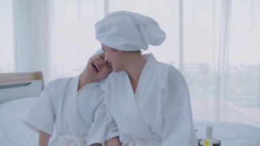 Spa konsepti. Anne ve kızı salatalık yüz bakımıyla eğleniyorlar. 4k Çözünürlüğü.