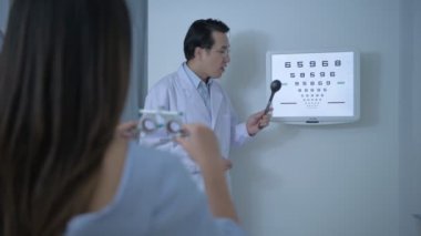 Optik dükkan konsepti. Göz doktoru, müşterinin gözlerini ölçüyor da. 4k Çözünürlüğü.