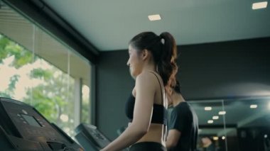 Fitness konsepti. Spor salonunda koşu bandında koşan bir sporcu. 4k Çözünürlüğü.