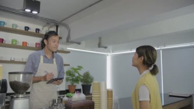 Kafe konsepti 4k Kararlılık. Asyalı erkek çalışanlar müşteri siparişlerini indiriyor..