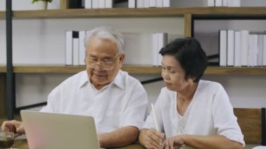 Aile kavramı 4k Kararlılığı. Ev bilgisayarlarında çalışan yaşlı bir çift..