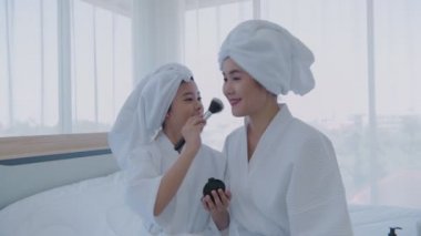Spa konsepti 4k Çözünürlük. Kız, annesi için yatak odasında makyaj yapıyor..
