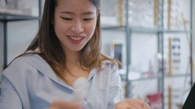 Optik dükkan konsepti 4k Kararlılık. Kullanmadan önce kontak lensleri yıkayan genç kadın.