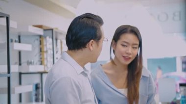 Optik dükkan konsepti 4k Kararlılık. Asyalı çift bir dükkanda gözlük test ediyor..