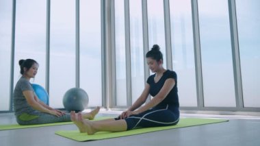 4k Çözünürlük alıştırması. Spor salonunda esneme hareketleri yapan bayan sporcular.