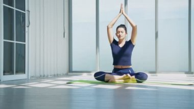 4k Çözünürlük alıştırması. Cam odada yoga yapan Asyalı kadın..