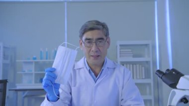 Araştırma konsepti 4K çözünürlüğü. Asyalı doktorlar sağ yüz maskesi takmayı öğretiyor..