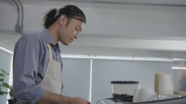 Kafe konsepti 4k Kararlılık. Asyalı erkek çalışanlar müşteriler için kahve yapıyor..