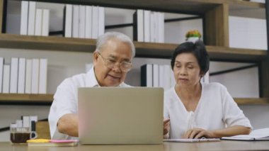 Aile kavramı 4k Kararlılığı. Ev bilgisayarlarında çalışan yaşlı bir çift..