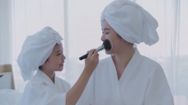 Spa konsepti 4k Çözünürlük. Kız, annesi için yatak odasında makyaj yapıyor..
