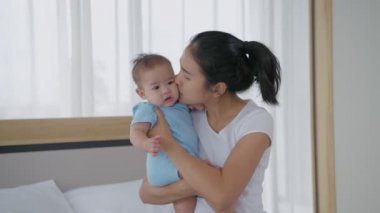 Aile kavramı 4k Kararlılığı. Asyalı annenin kucağında bir bebek var..