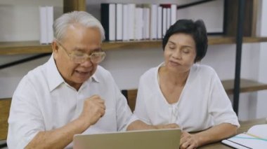 Aile kavramı 4k Kararlılığı. Ev bilgisayarlarında çalışan yaşlı bir çift..