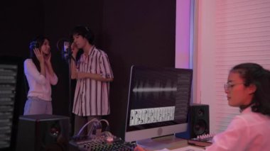 4k Çözünürlük ses kaydı konsepti. Asyalı erkek ve kadın çift stüdyoda şarkı söylüyor..