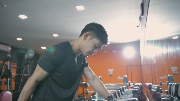 4K解像度的健康概念 一个年轻的亚洲男人走进来 举起了一个哑铃 — 图库视频影像