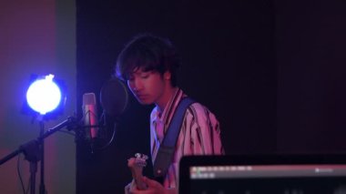 4k Çözünürlük ses kaydı konsepti. Müzisyenler stüdyoda eğlencesine gitar çalıyorlar..