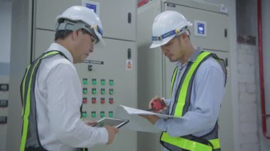 Mühendislik konsepti 4k Çözünürlük. Teknisyen takım liderini bir iletişim cihazıyla koordine ediyor..
