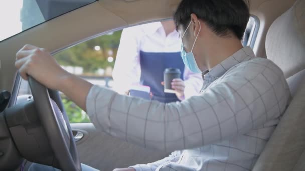 4K解像度のコーヒーショップのコンセプト 男性アジアの顧客は従業員から彼の車に配達されたコーヒーを得ています — ストック動画