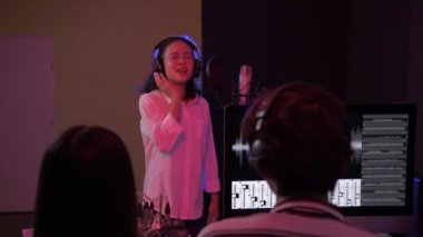 4k Çözünürlük ses kaydı konsepti. Genç bir Asyalı şarkıcı stüdyoda kayıt yapıyor..