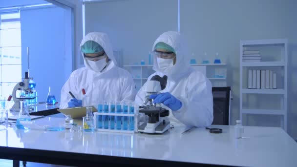 4K分解能の研究コンセプト 科学者は研究室で働くために防護服を着用する — ストック動画