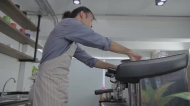 Barista 'nın 4k çözünürlük kavramı. Asyalı erkek çalışan kahve makinesiyle kahve yapıyor..