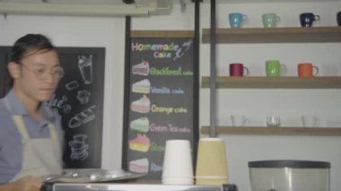 Barista 'nın 4k çözünürlük kavramı. Çalışan dükkanda içki için konteynır hazırlıyor..