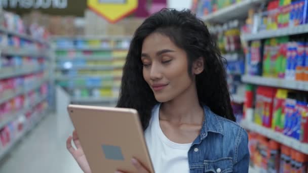 购买4K解像度的概念 一位年轻女子用平板电脑在商场里搜寻商品 — 图库视频影像