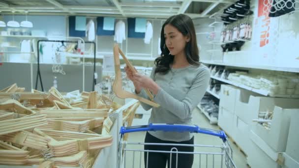 4K解像度のショッピングコンセプト ショッピングモールでの服のハンガーのためのアジアの女性のショッピング — ストック動画