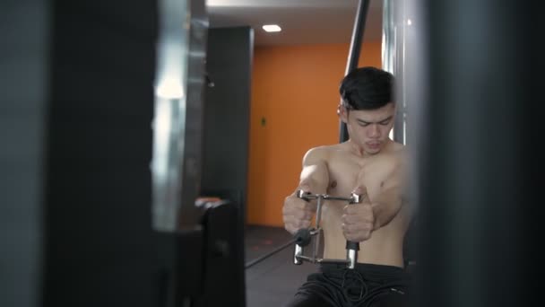 4K解像度のフィットネスコンセプト アジア人男性持ち上げる重量でザケーブルマシンでザジム — ストック動画