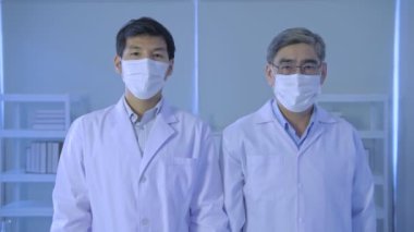 Araştırma konsepti 4K çözünürlüğü. Bilim adamları laboratuara güvenerek kollarını kavuşturdular..
