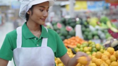 4k Kararlılığın alışveriş kavramları. Kız alışveriş merkezindeki raflara meyve ve sebze ekliyor.. 