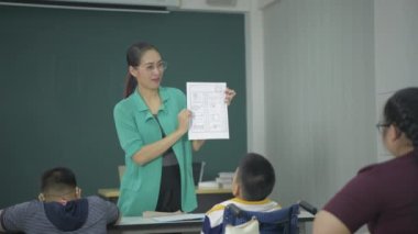Eğitim konsepti 4k Kararlılık. Öğretmen engelli çocuklara resim çizmeyi öğretiyor..