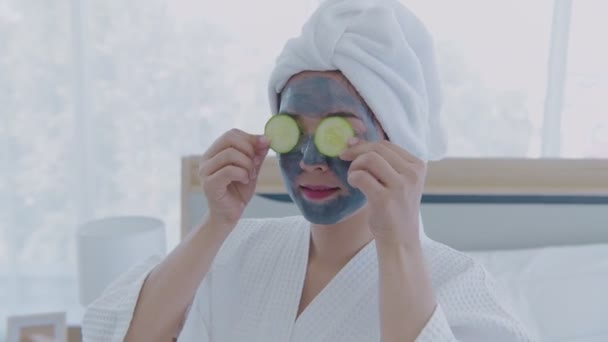 Spa konsep resolusi 4k. Gadis Asia menempatkan mentimun di matanya di kamar tidur. — Stok Video