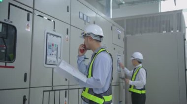 Mühendislik konsepti 4k Çözünürlük. Teknisyen takım liderini bir iletişim cihazıyla koordine ediyor..