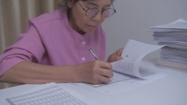 4k Kararlılığın iş konsepti. Asyalı yaşlı kadınlar belgeleri kontrol etmekle meşguller..