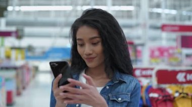 4k Kararlılığın alışveriş kavramları. Genç kadınlar alışveriş merkezinde mal aramak için cep telefonu kullanırlar..