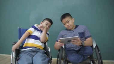 Eğitim konsepti 4k Kararlılık. Engelli çocuklar tabletle oyun oynuyorlar..