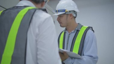 Mühendislik konsepti 4k Çözünürlük. Teknisyen takım liderini bir iletişim cihazıyla koordine ediyor..