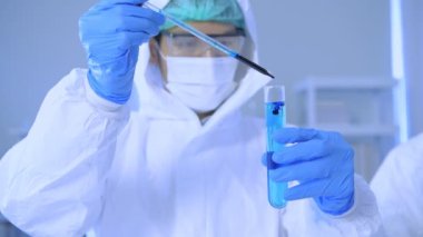 Araştırma konsepti 4K çözünürlüğü. Bilim adamları çözeltiyi test tüpünde inceliyorlar..