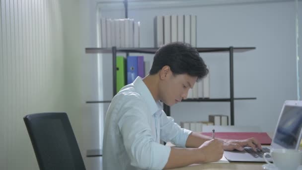 4K解像度のビジネスコンセプト 若いアジア人男性はオフィスで働くのに疲れている — ストック動画